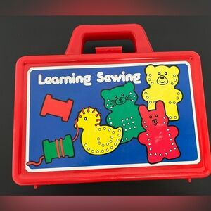 Red and Green Learning Sewing Kit with Plastic Needle included.